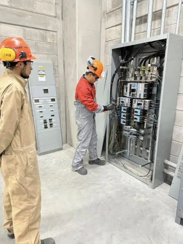 Técnicos trabajando en tablero eléctrico industrial